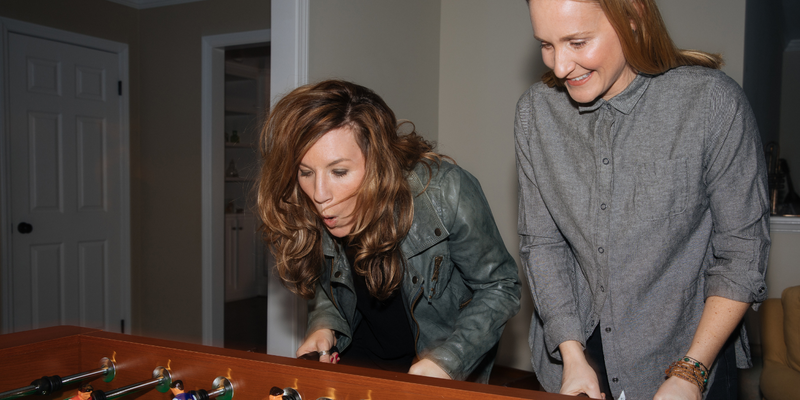 Two woman having fun playing foosball